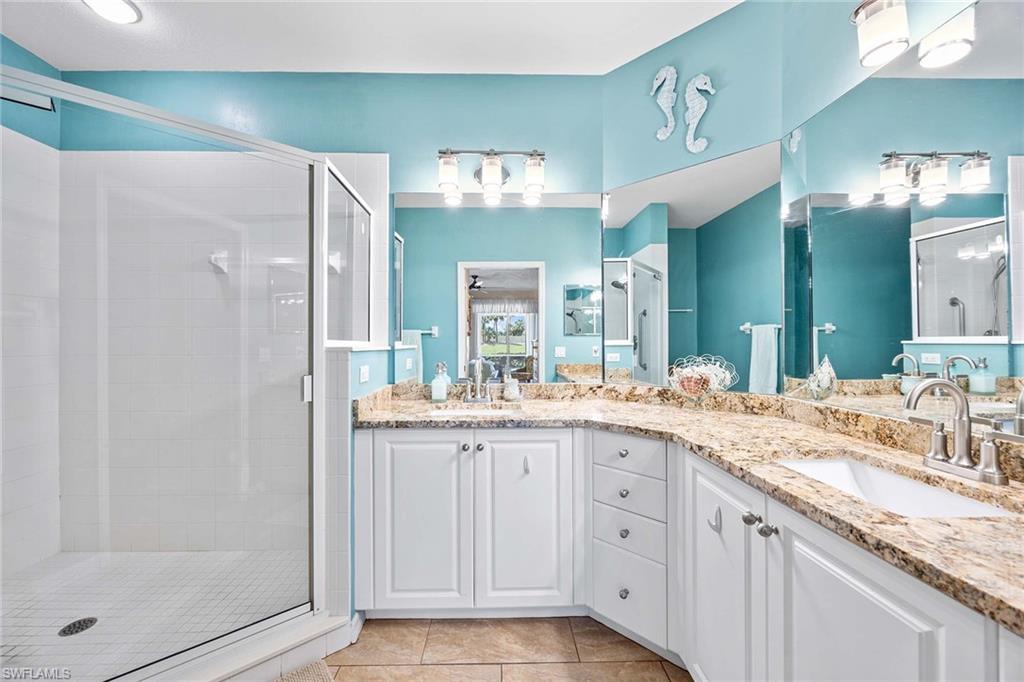 7000 Pinnacle Lane, Unit 1401 Naples, FL 34110 - Photo 14 of 49 a bathroom with a granite countertop sink and a mirror