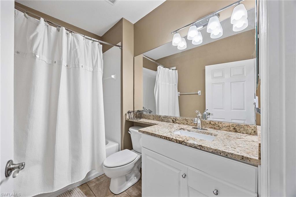 7000 Pinnacle Lane, Unit 1401 Naples, FL 34110 - Photo 16 of 49 a bathroom with a granite countertop sink and a mirror