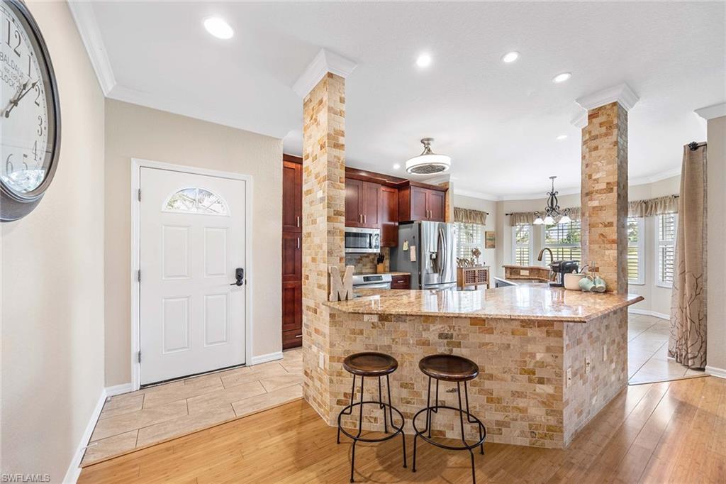 7000 Pinnacle Lane, Unit 1401 Naples, FL 34110 - Photo 4 of 49 a kitchen with a dining table and chairs