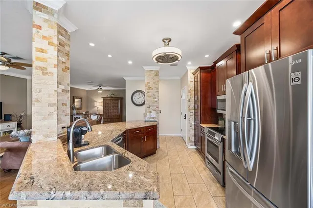 a kitchen with stainless steel appliances granite countertop a refrigerator and a sink