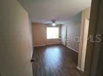 a view of a refrigerator in kitchen and an empty room