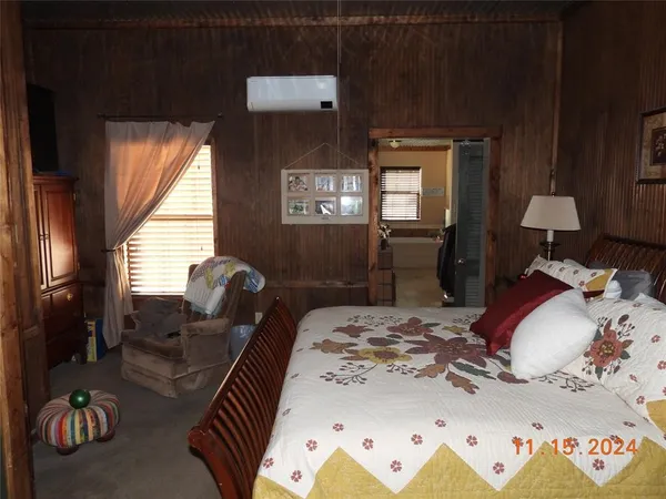 a bedroom with bed and a large window