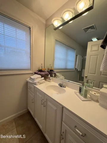 a bathroom with a double vanity sink and a mirror