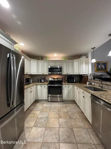 a large kitchen with a stove top oven a sink and cabinets