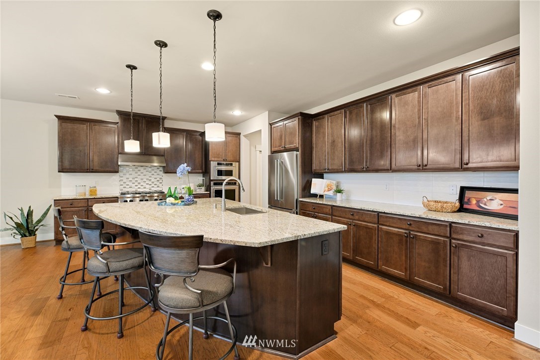 15927 98th Avenue Northeast Bothell, WA 98011 - Photo 11 of 33 a kitchen with stainless steel appliances kitchen island granite countertop a sink a stove a dining table and chairs