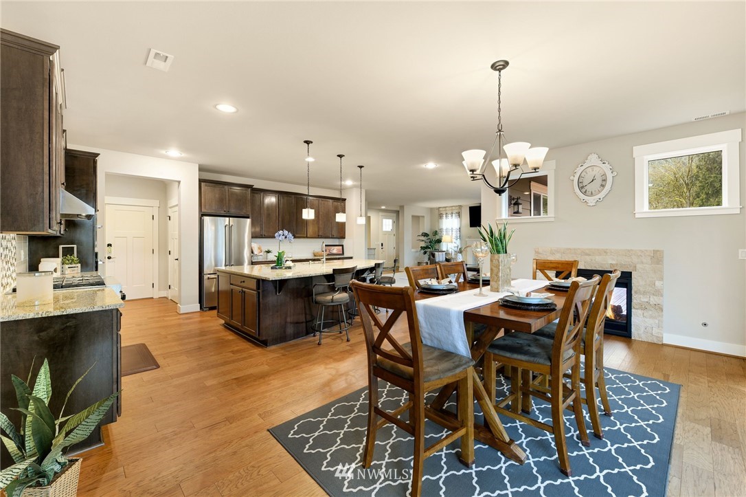 15927 98th Avenue Northeast Bothell, WA 98011 - Photo 7 of 33 a view of a dining room and livingroom with furniture wooden floor a rug a chandelier and a mirror