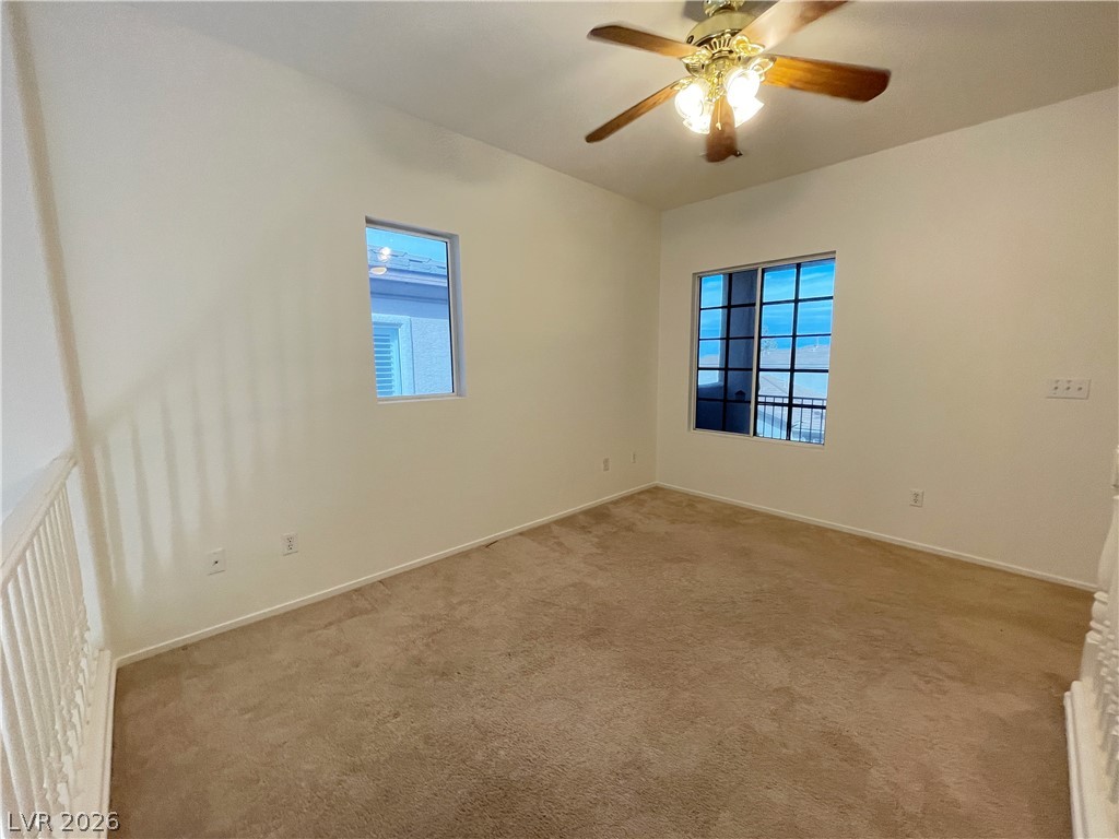 691 Principle Point Avenue Henderson, NV 89012 - Photo 23 of 30 A well-lit loft space features carpeting, a ceiling fan, and ample window light.