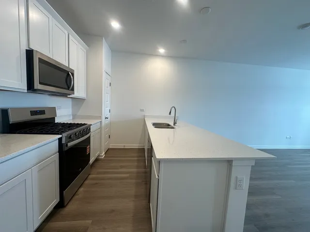 a large kitchen with a sink and stainless steel appliances