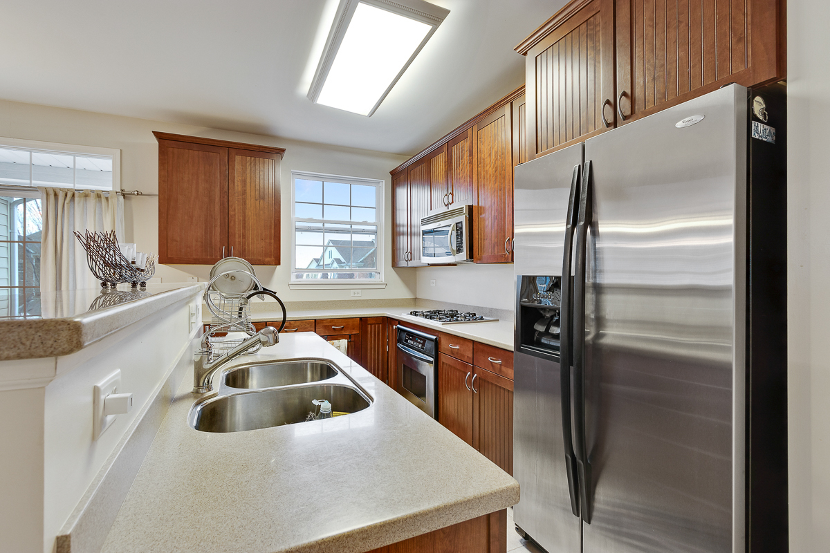 1358 Scarboro Road, Unit 806 Schaumburg, IL 60193 - Photo 4 of 16 a kitchen that has a refrigerator a sink a stove and cabinets