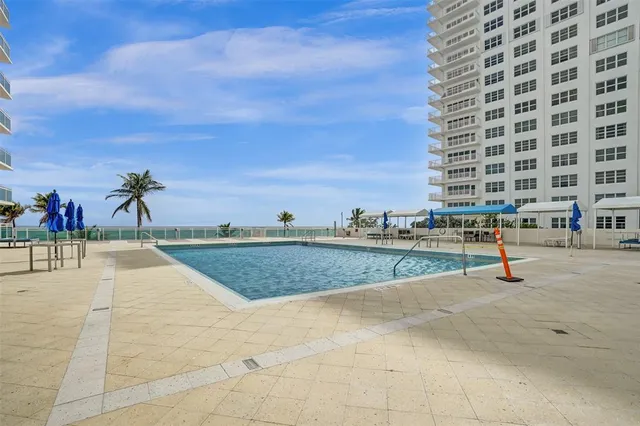 a view of a chairs and table on the patio in front of building