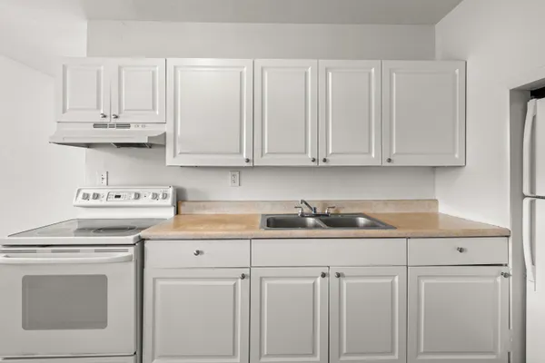 a kitchen with white cabinets and white appliances