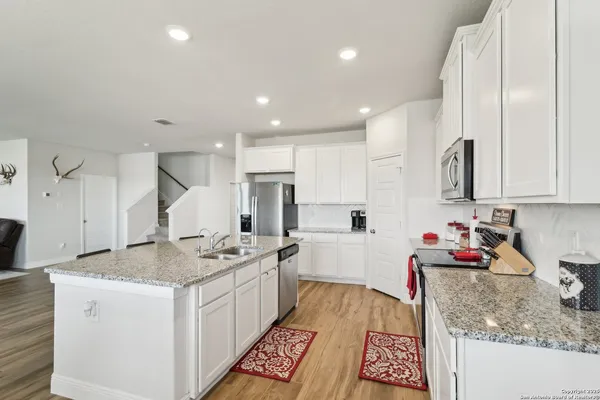 a kitchen that has a lot of cabinets and wooden floor
