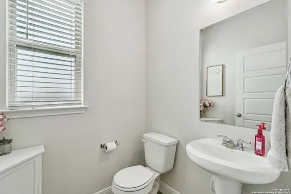 a bathroom with a sink mirror and toilet