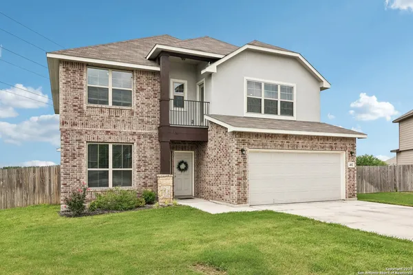 a front view of a house with a garden and yard