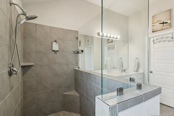 a bathroom with a double vanity sink mirror and shower