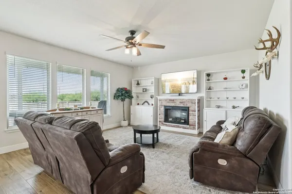 a living room with furniture fireplace and a large window