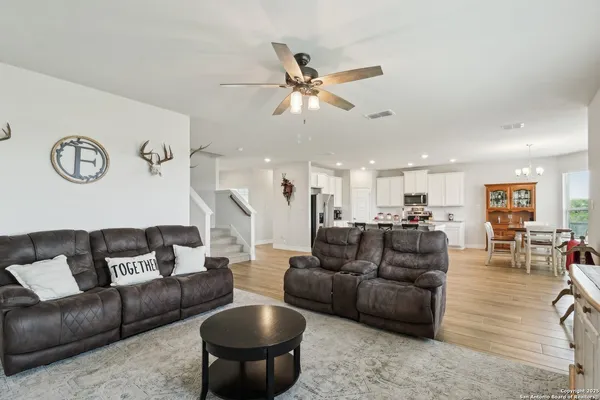 a living room with furniture and a ceiling fan