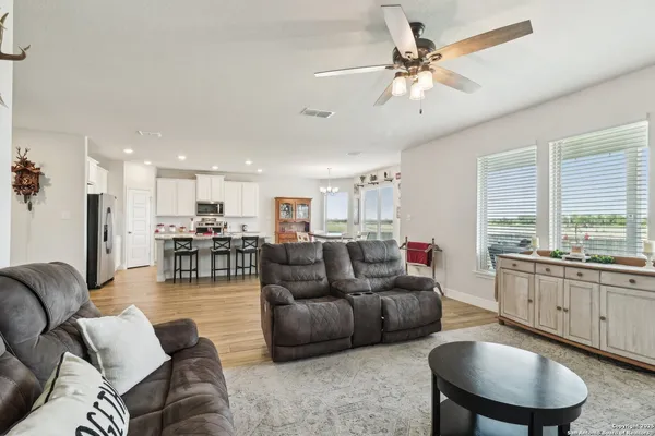 a living room with furniture kitchen view and a large window