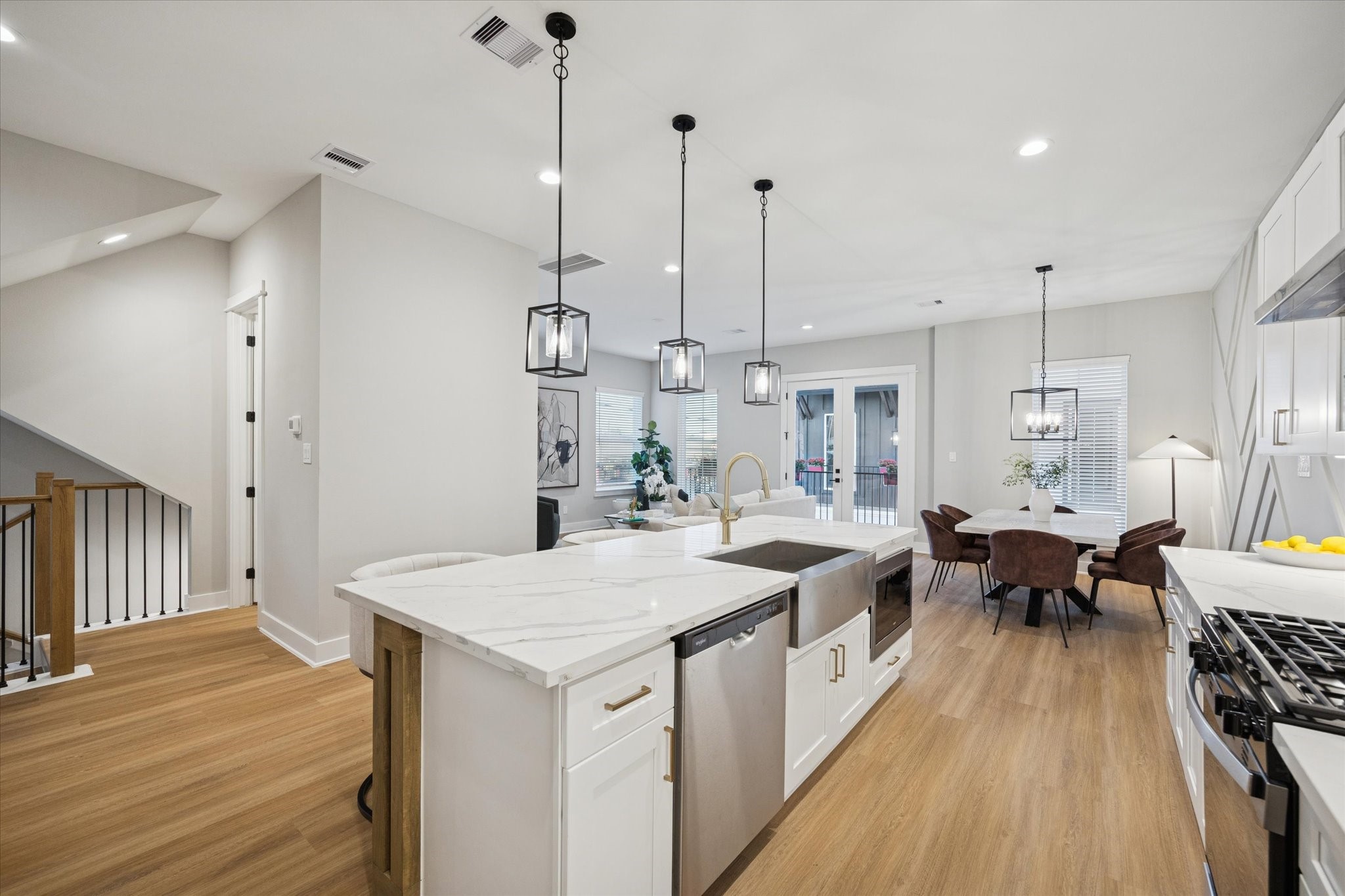 719 Thornton Road, Unit C Houston, TX 77018 - Photo 4 of 45 a large kitchen with kitchen island a island a stove a wooden floor and a chandelier