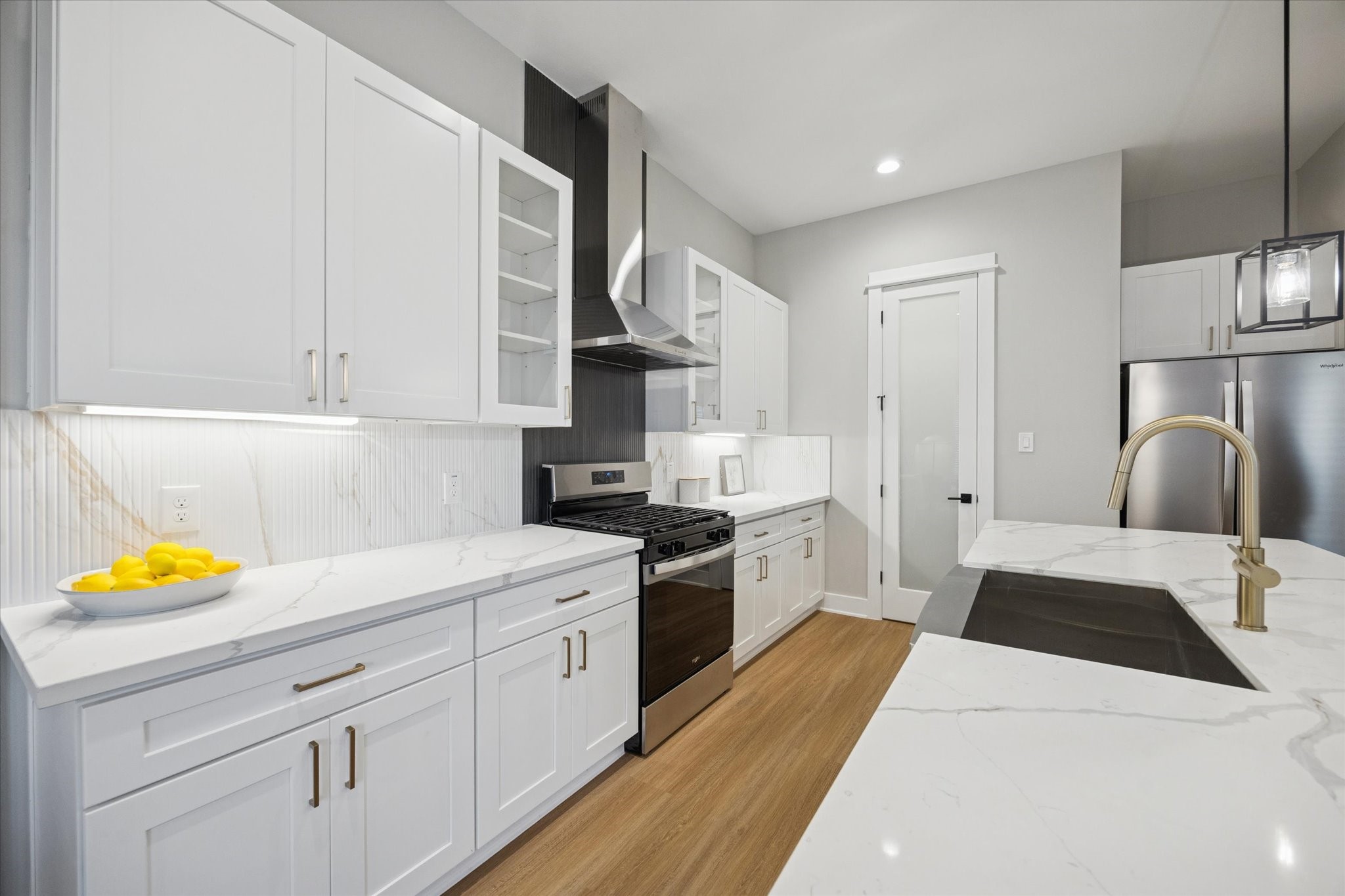 719 Thornton Road, Unit C Houston, TX 77018 - Photo 8 of 45 a kitchen with a sink dishwasher and white cabinets with wooden floor