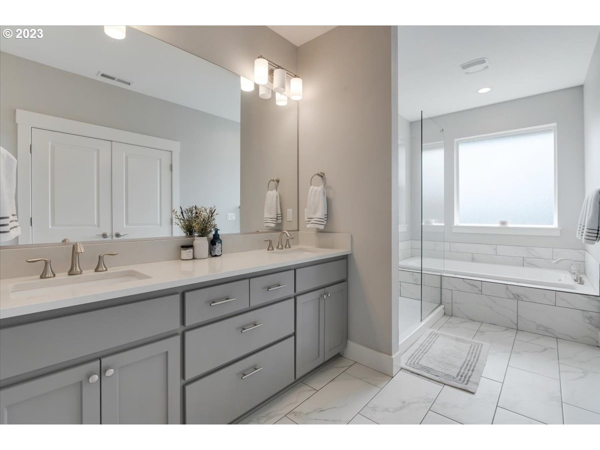 2754 Northwest Inna Avenue Salem, OR 97304 - Photo 21 of 36 a bathroom with a double vanity sink a mirror and a bathtub