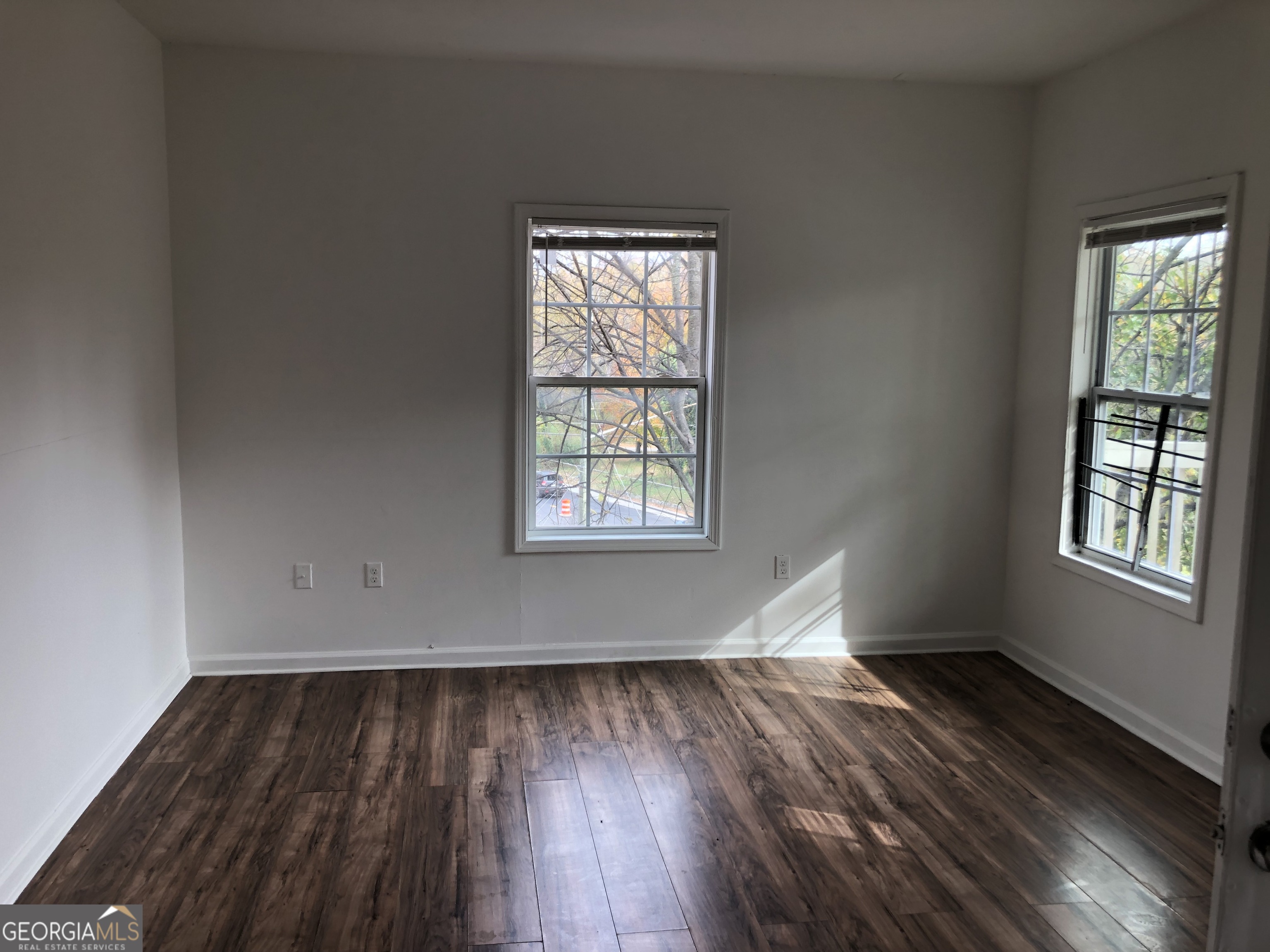 2457 Donald Lee Hollowell Parkway Northwest, Unit A Atlanta, GA 30318 - Photo 9 of 12 an empty room with wooden floor and windows