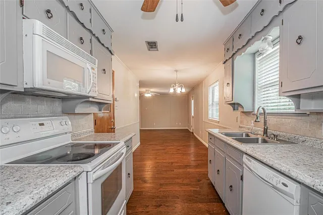 a kitchen with stainless steel appliances granite countertop a sink stove and cabinets
