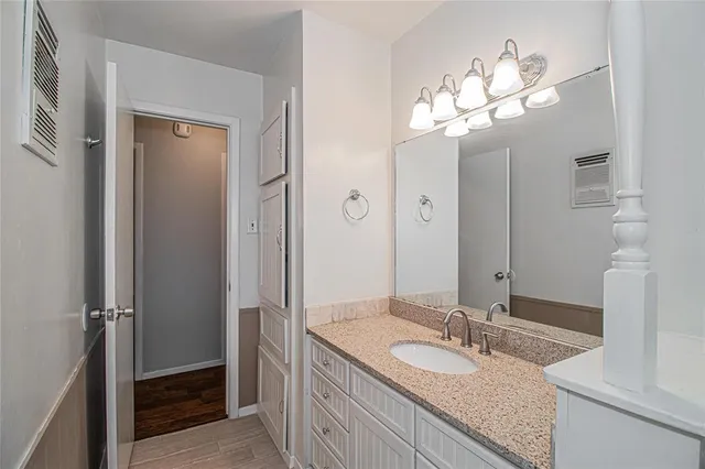 a bathroom with a granite countertop sink a light fixture and a mirror