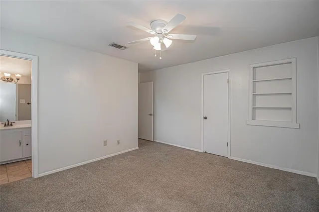 an empty room with closet and fan