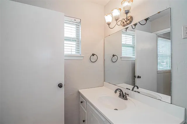 a bathroom with a sink a mirror and a window