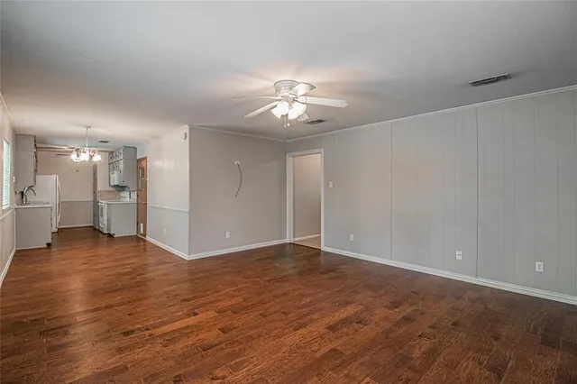a view of empty room with wooden floor and a ceiling fan