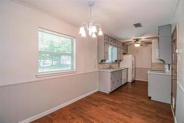 a kitchen with a refrigerator and white cabinets