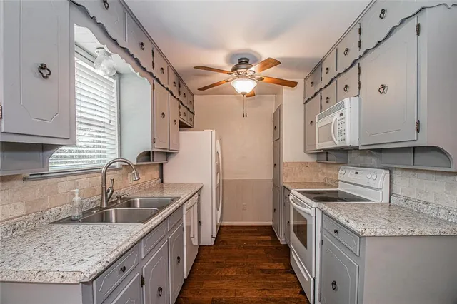 a kitchen with stainless steel appliances granite countertop a sink a stove and a wooden floors