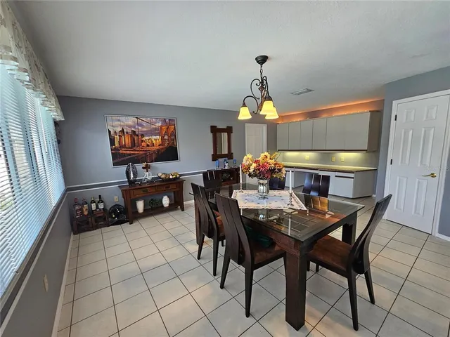 a livingroom with dining area a flat screen tv and a window
