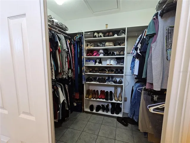 a view of walk in closet with clothes and shoes