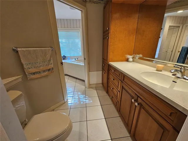 a bathroom with a sink a toilet a mirror and vanity