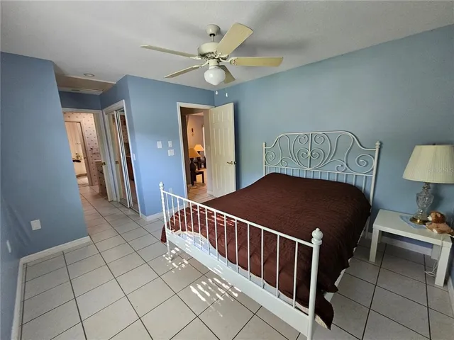 a bedroom with a bed and a ceiling fan