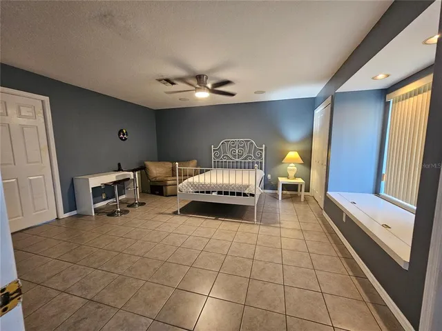 a bed room with a bed window and a chair