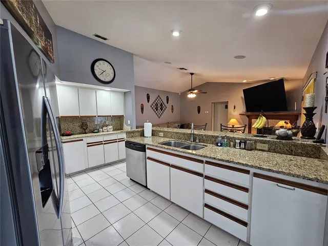 a kitchen with stainless steel appliances granite countertop a sink and a stove top oven