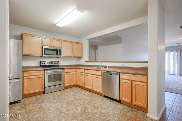 a kitchen with granite countertop white cabinets and stainless steel appliances
