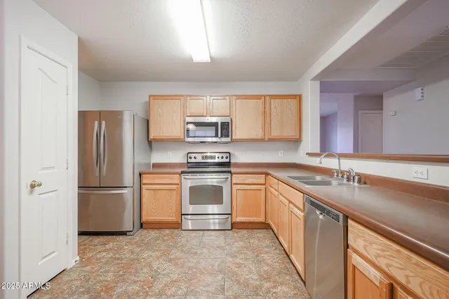 a kitchen with stainless steel appliances granite countertop a refrigerator sink and stove