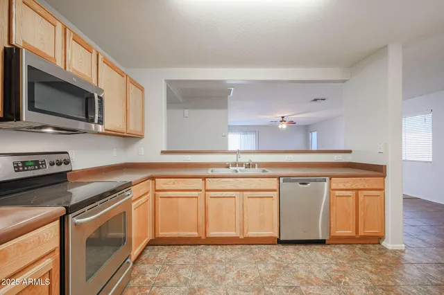 a kitchen with stainless steel appliances granite countertop a sink stove and microwave
