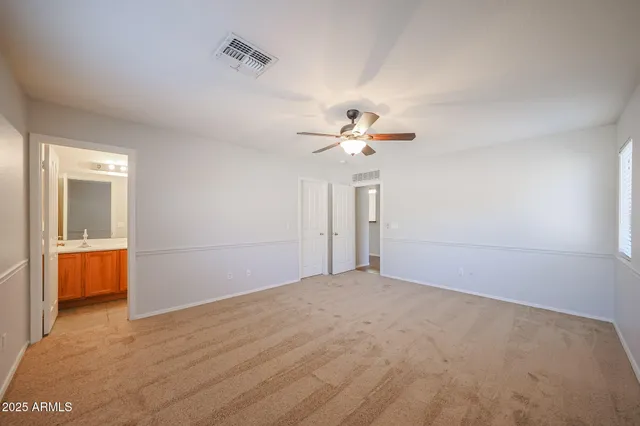 a view of an empty room with a chandelier fan