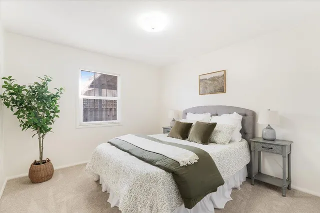 a bedroom with a bed and a potted plant