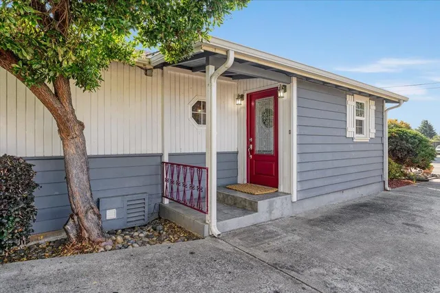 a view of a house with wooden fence and a tree