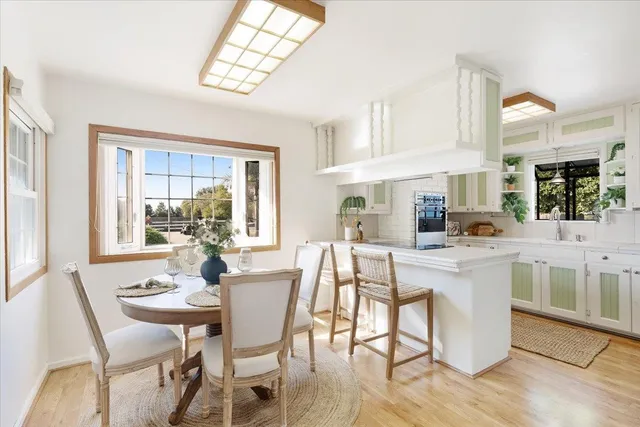 a kitchen with a dining table chairs and white cabinets