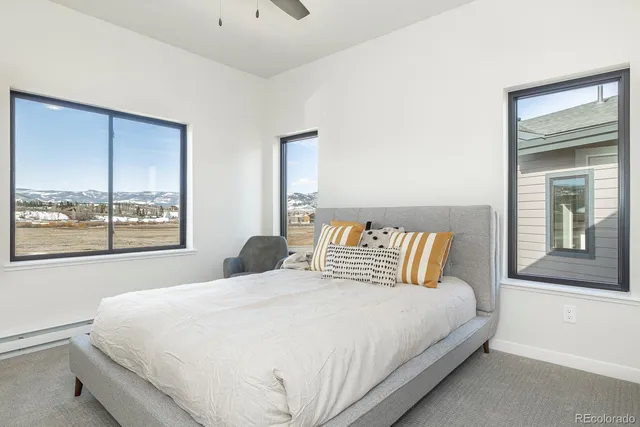 a bedroom with a bed couch and a large window