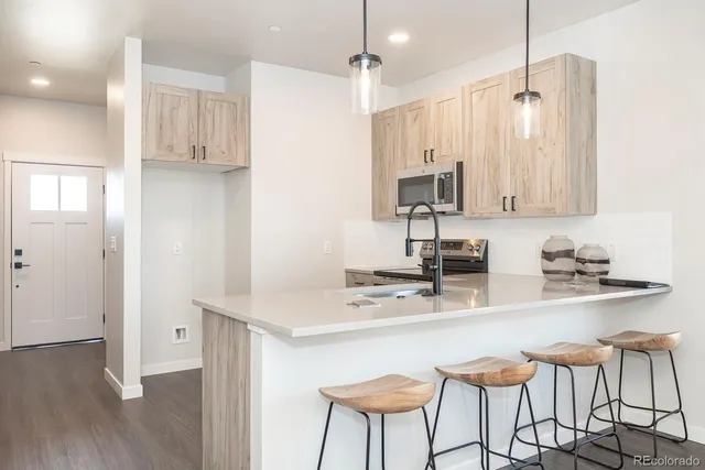a kitchen with stainless steel appliances granite countertop a sink refrigerator and cabinets
