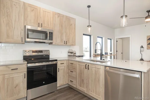 a kitchen with stainless steel appliances granite countertop a stove a sink and a microwave