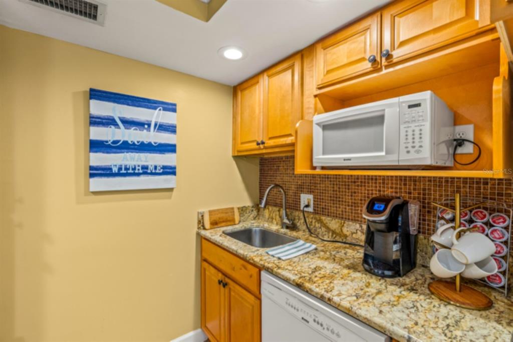 8911 Blind Pass Road, Unit 223 St. Pete Beach, FL 33706 - Photo 15 of 27 a kitchen with a sink and cabinets